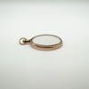Flat angle of antique gold and glass pendant showing slim profile and smooth finish