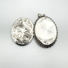 Open locket displaying contrasting front and back engraved designs in silver