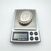 Digital scale showing weight of vintage silver locket as 19.4 grams