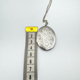 Width of vintage silver locket pendant shown beside tape measure