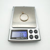 Antique 9ct gold glass locket pendant on digital scale weighing 3.67 grams