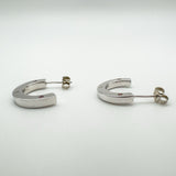 Low angle side view displaying the thickness and shine of the silver hoop earrings