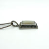Low angle side view of the sterling silver pendant and chain, highlighting the raised square profile and finish.