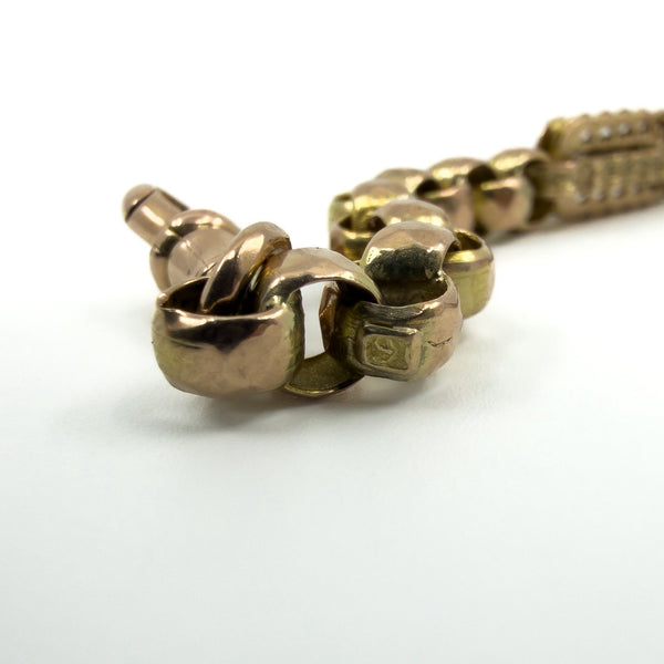 Low angle detail of the antique rose gold Albert chain with mixed yellow and rosy gold tones