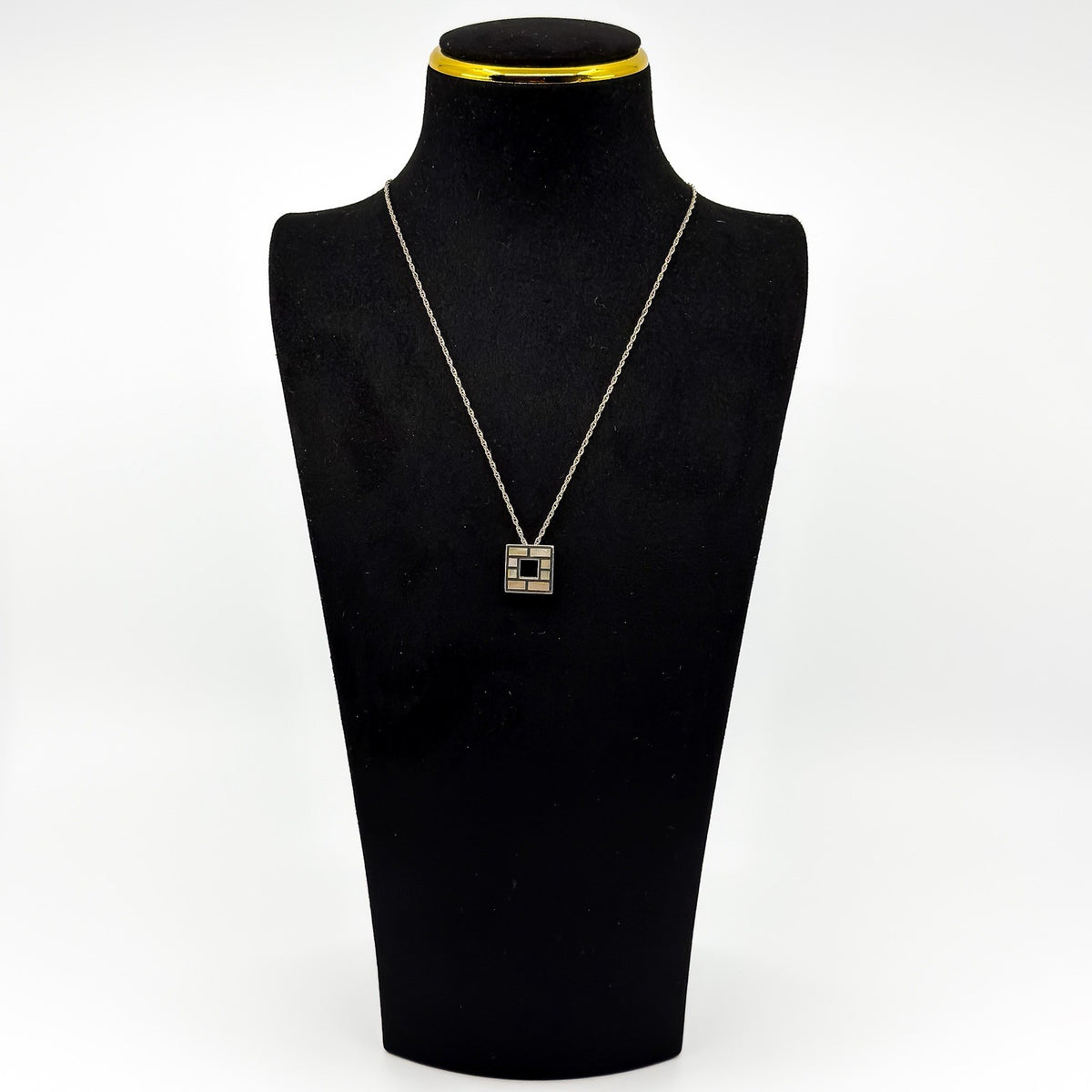 Vintage sterling silver Kit Heath mother of pearl pendant shown on a black display bust