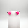 Trillion cut neon pink fire opal stud earrings shown on a white display card