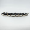 Side profile of chunky sterling silver black onyx bracelet showing raised cabochon bezel settings