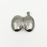 Open oval sterling silver photo locket showing matching engraved outer covers
