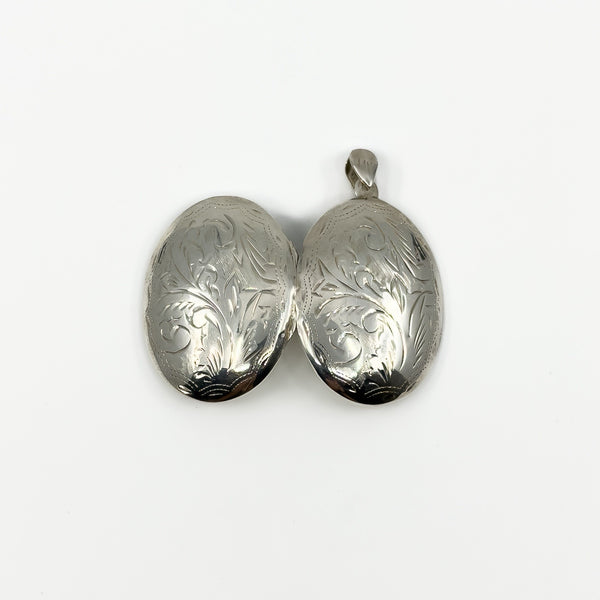 Open oval sterling silver photo locket showing matching engraved outer covers
