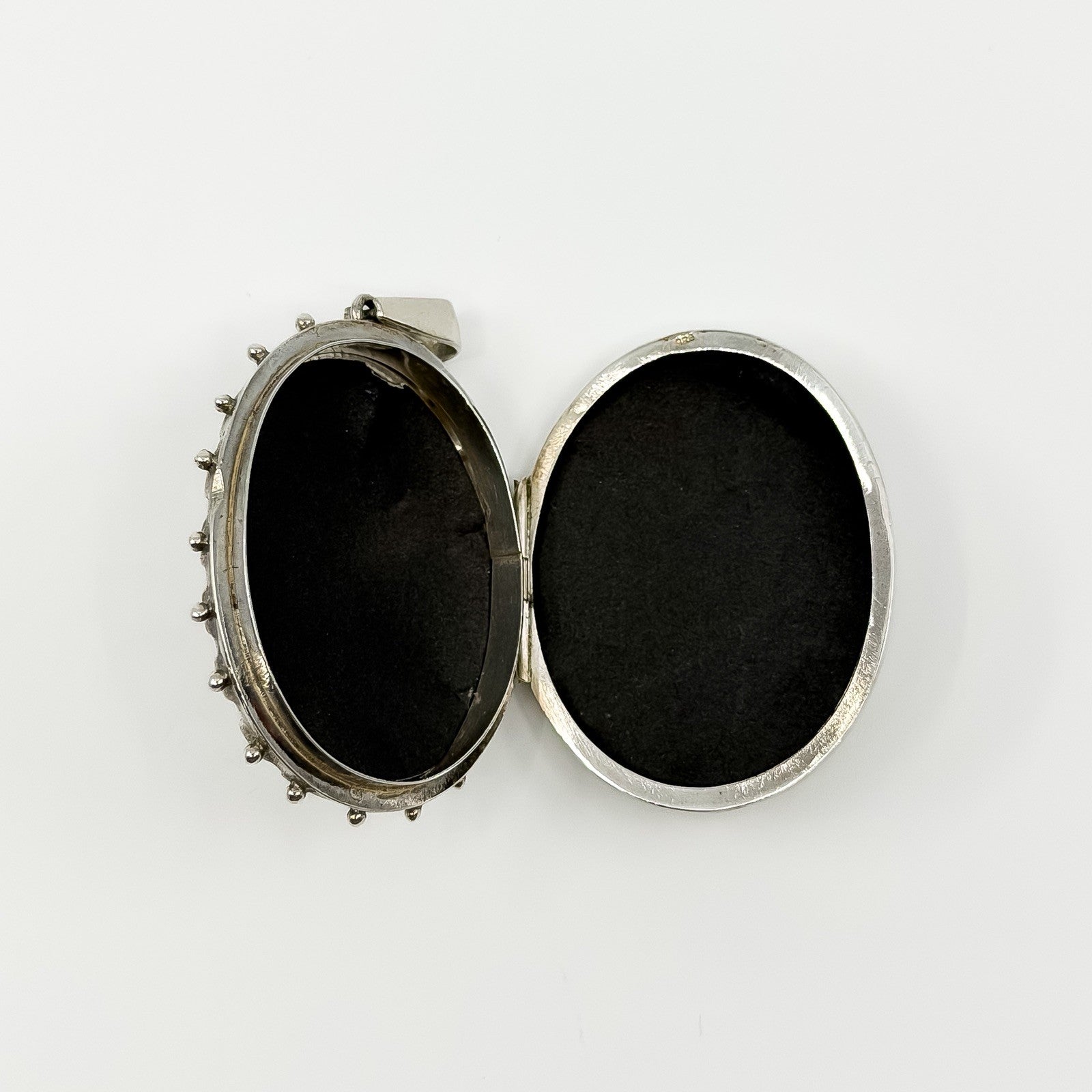 Open vintage sterling silver oval locket showing space inside for two photos or keepsakes