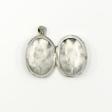 Open sterling silver oval photo locket showing the plain interior and hinge
