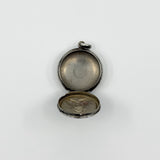 Open vintage sterling silver photo locket pendant showing space inside for small photos.