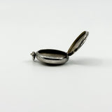 Open side profile of vintage sterling silver Virgin Mary photo locket showing the photo compartment.
