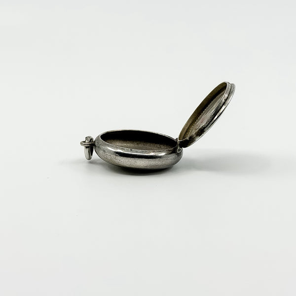Open side profile of vintage sterling silver Virgin Mary photo locket showing the photo compartment.