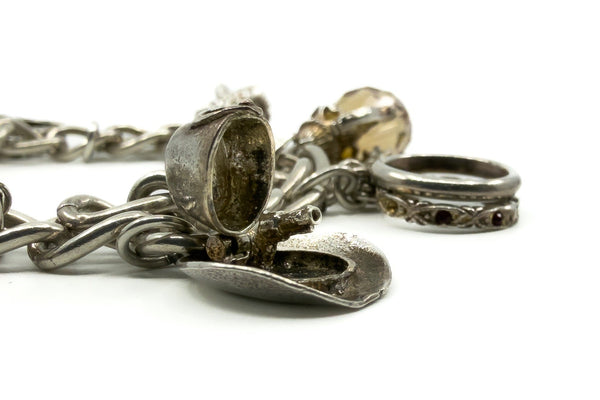 Close up of opening cowboy hat charm on vintage sterling silver charm bracelet with aged silver detail.