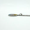 Sterling silver oval inlay pendant shown side-on while on chain, highlighting the smooth polished edge.