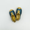 Top view of large gold-tone brooch with blue crystal shoes detail