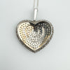 Reverse side of diamond heart pendant showing pierced design