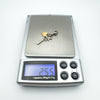 Digital scale showing charm pendant weighs 2.55 grams