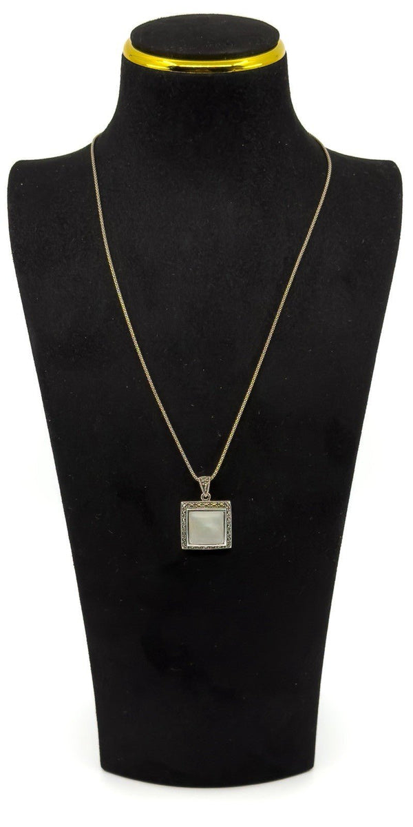 Sterling silver mother of pearl and marcasite pendant necklace shown worn on a bust for length and scale.