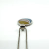 Close-up of sterling silver oval inlay pendant with smooth bail and fine box chain, multicolour inlay detail.