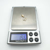 Antique diamond pendant on scale reading 1.56 grams