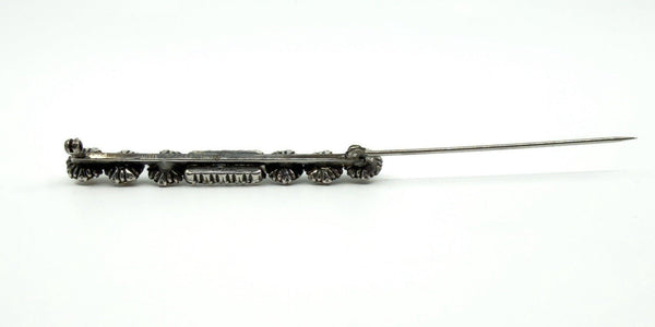 Side view of the paste and pearl bar brooch with pin open, showing the long needle and hinge.