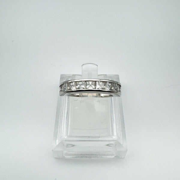 Sterling silver ring featuring a row of princess-cut Moissanites in a secure channel setting, displayed on a clear stand