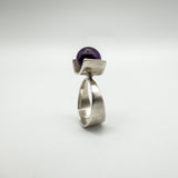 Profile view of bold vintage ring with purple amethyst and wide silver band