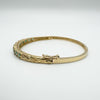 Side angle showing secure clasp on oval emerald and diamond bangle