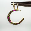 Underside of ruby and diamond horseshoe pendant shown with tweezers