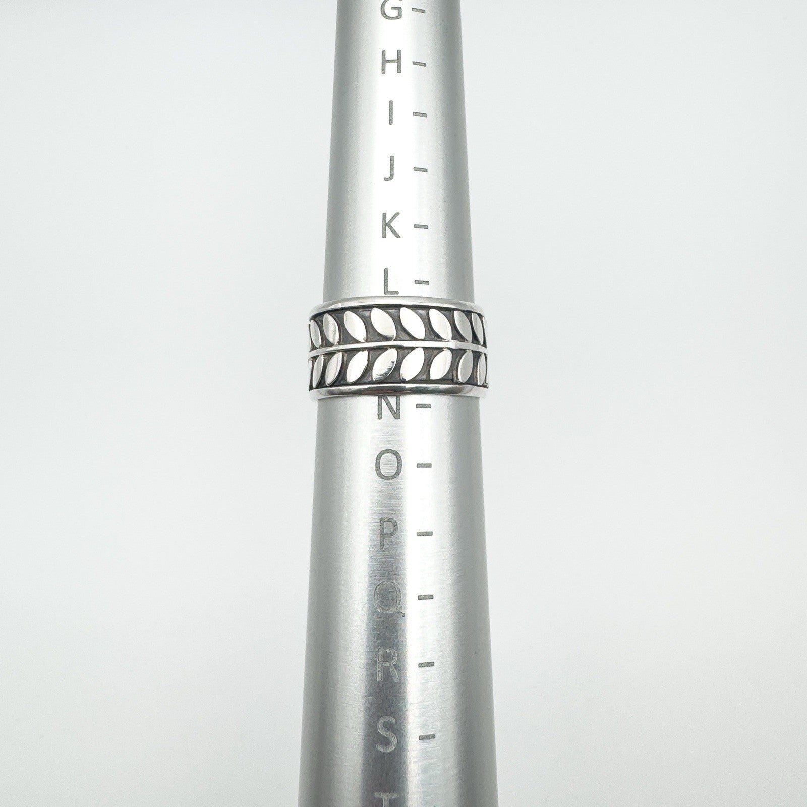 Wide sterling silver ring on mandrel showing UK ring size L