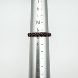 Vintage garnet eternity ring on sizer showing UK ring size N to O