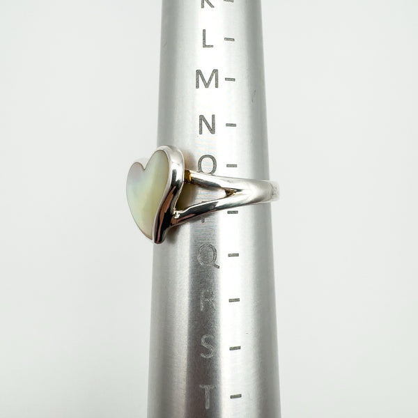 White mother of pearl heart ring shown on ring sizer at UK size N to O