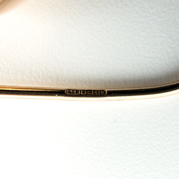 Close-up of 9ct rose gold earring wire stamped 375 with hallmark details visible