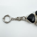 Close up of round toggle clasp and chain links on chunky sterling silver black onyx bracelet