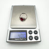 Ruby and diamond ring placed on digital scale displaying weight of 4.00g