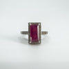 Close-up of 4ct emerald cut ruby ring with natural diamond halo