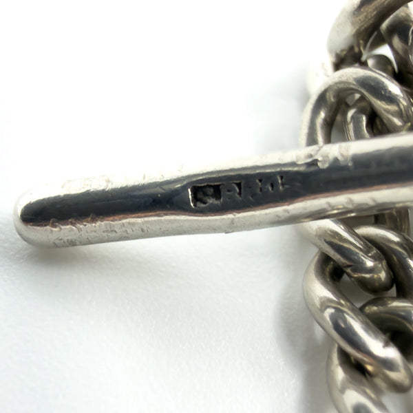 Macro close-up of the T-bar showing the S BROS maker’s mark on the antique sterling silver Albert chain.