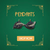 Gold pendant with sapphire and diamond leaf design on green background