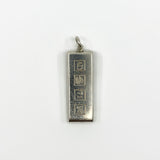 Close up of the front of a chunky sterling silver ingot pendant with Sheffield style hallmark blocks.