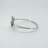 Side angle showing curvature and silver band of the oval bangle