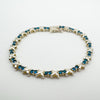 Side angle of sterling silver tennis bracelet with prong set blue CZs