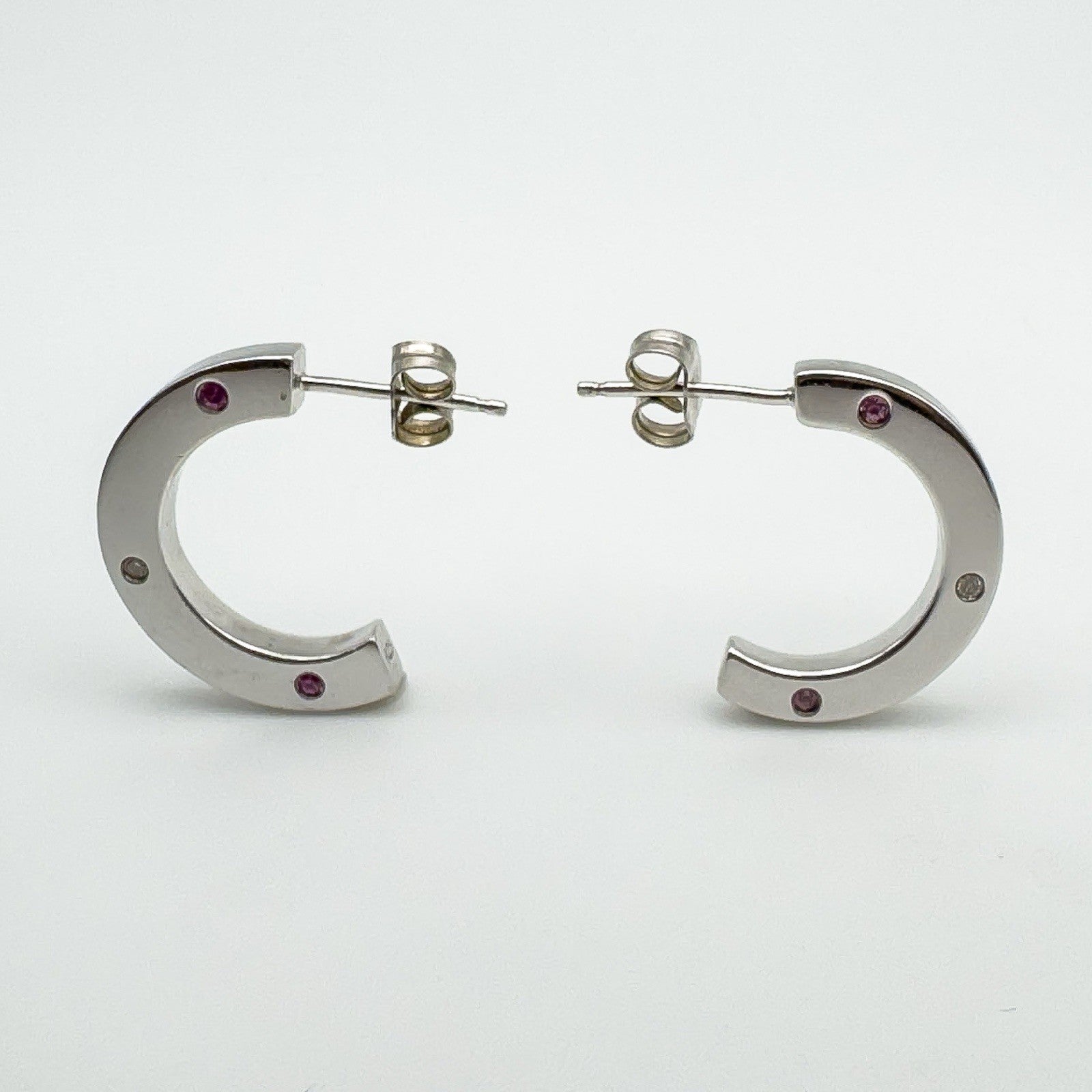 Side view showing curved chunky shape and asymmetric pink sapphire and diamond settings