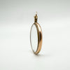 Slim side view of antique double-sided glass locket with gold edge and bail