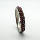 Detailed side view of full eternity garnet ring with antique hand-cut stones