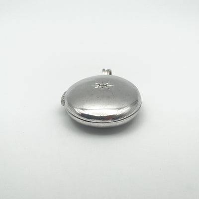 Side view of oval locket showing diamond starburst on front