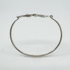Side profile showing oval shape of sterling silver bangle with open clasp