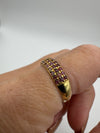 Side angle of ruby pavé band on hand showing curved gold finish