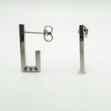 Side view of sterling silver J hoop earrings showing post and pink sapphire and diamond detail